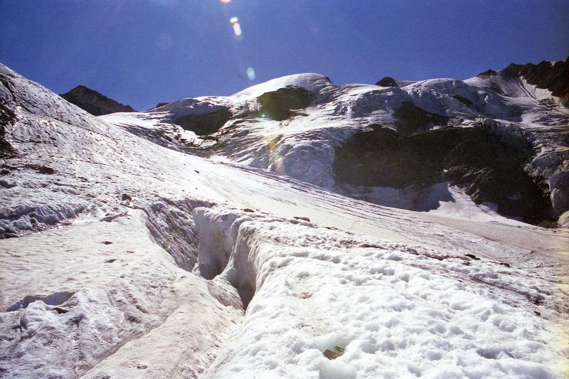 Gletscher mit Spalten und Eisformationen unter blauem Himmel