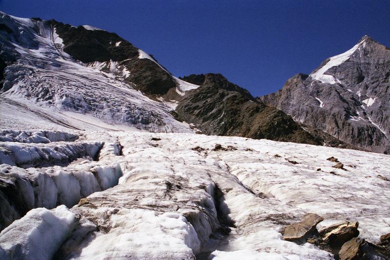 Gletscher mit Spalten und schneebedeckten Berggipfeln
