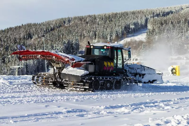 Pistenraupe im verschneiten Skigebiet