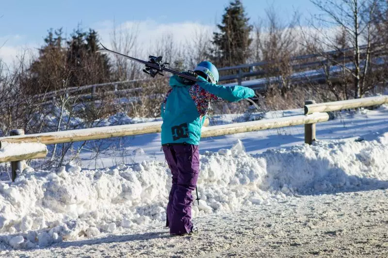 Wintersportlerin mit Ski und Jacke
