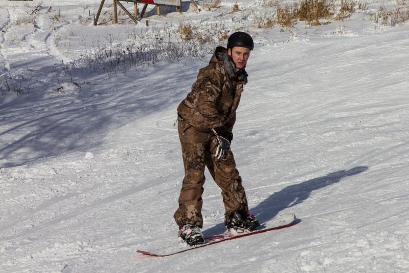 Snowboarder mit schwarzem Helm im Schnee