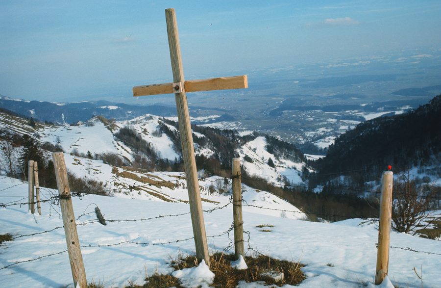 Gipfelkreuz im verschneiten Solothurner Jura mit Blick aufs Mittelland