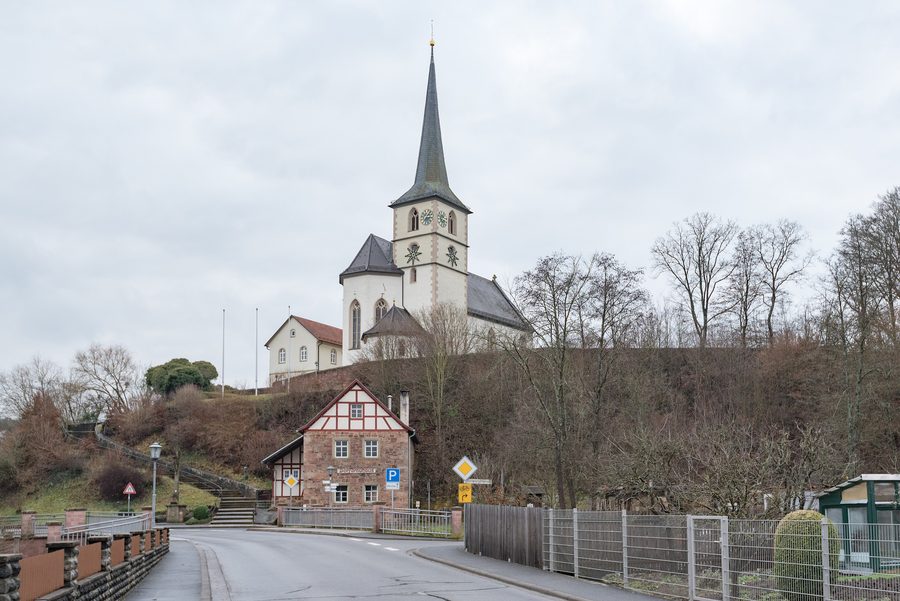Julius-Echter-Kirche mit Pfarrhaus und historischem Brauhaus in Schönau an der Brend