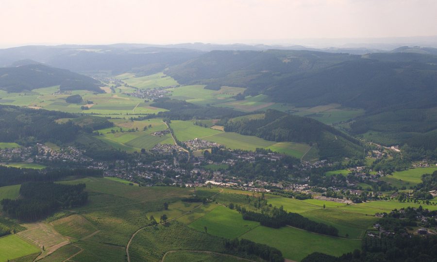 Luftaufnahme von Eslohe mit dem Steltenberg und waldreichen Hügeln im Sauerland