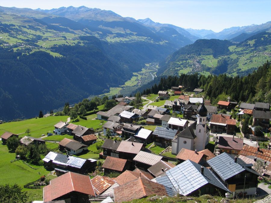 Blick auf das Bergdorf Siat in der Schweiz mit dem Rheintal und Bergen im Hintergrund