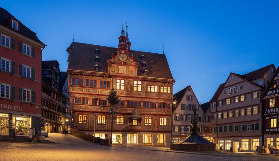 Historisches Rathaus am Marktplatz in Tübingen mit umliegenden restaurierten Gebäuden in der blauen Stunde