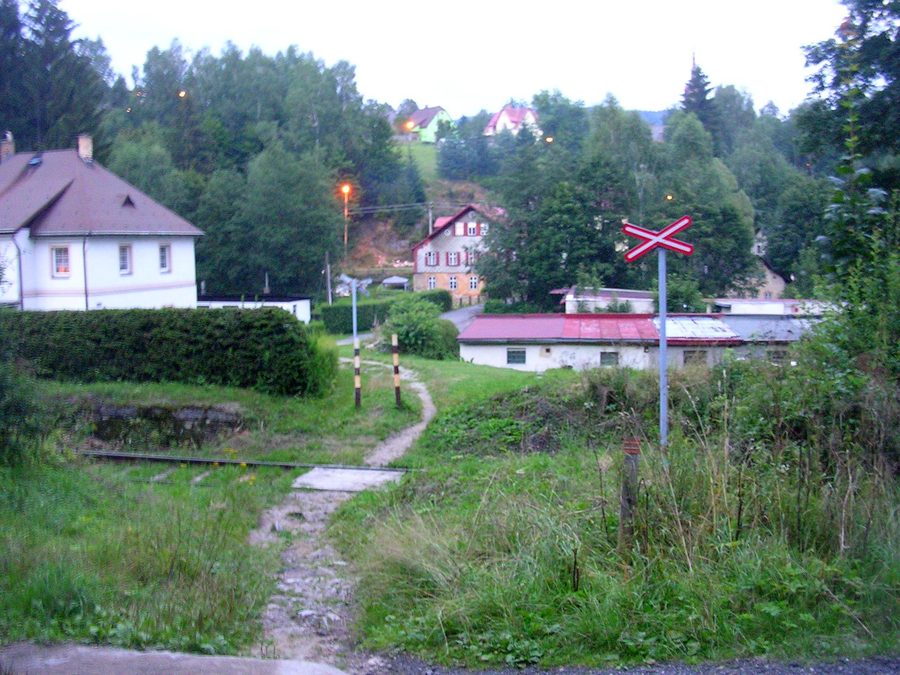 Blick auf Desná mit einem Bahnübergang im Isergebirge