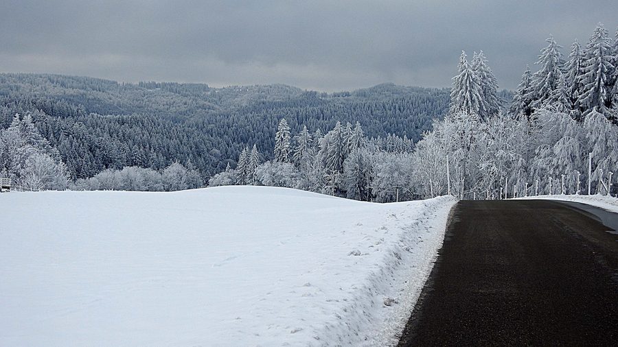 Verschneite Landschaft bei Wiggensbach mit Blick auf den Kürnachwald