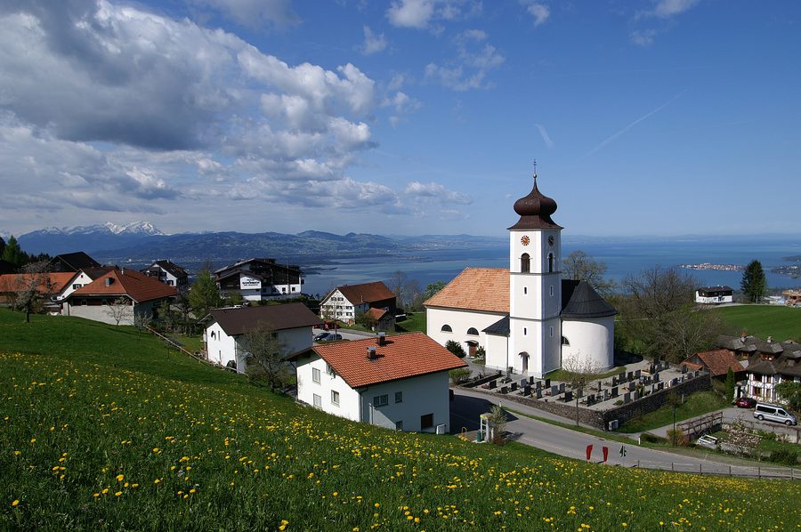 Blick über Eichenberg mit der Pfarrkirche St. Bernhard auf den Bodensee und die Schweizer Berge