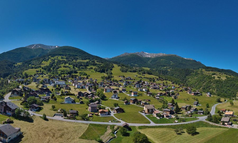 Das Dorf Unterbäch im Sommer 2022 vor alpiner Bergkulisse