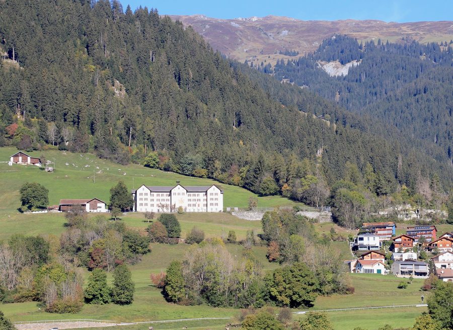 Burghügel mit den Ruinen der Burg Löwenberg bei Schluein und dem Neubau links