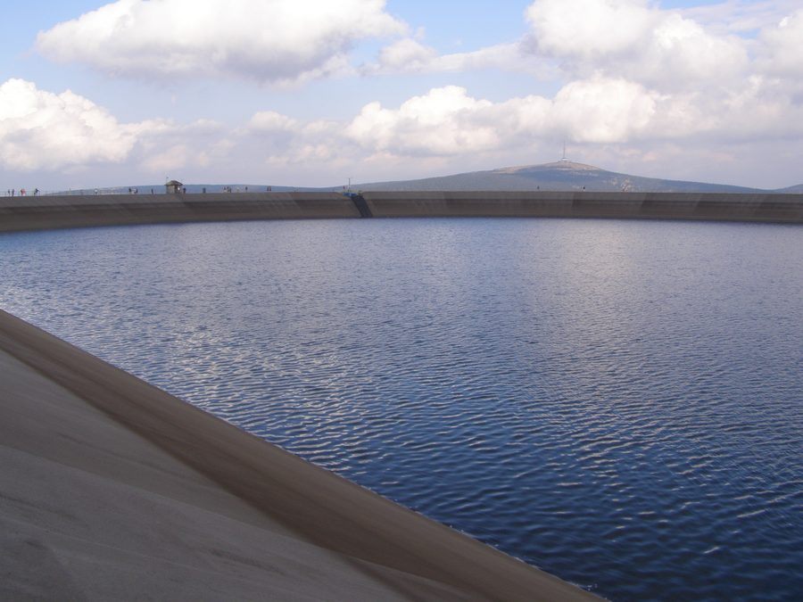 Obere Staumauer der Dlouhé-Stráně-Talsperre mit Berggipfel Praděd im Hintergrund