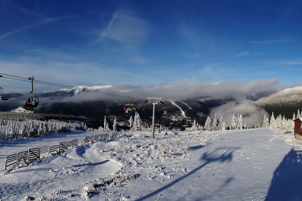 Verschneite Pisten, Sessellifte und Bergpanorama im Skigebiet Špindlerův Mlýn in Tschechien.