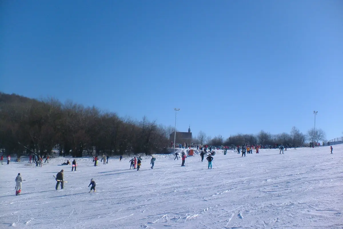 Skifahrer auf der verschneiten Anfängerpiste des Sípark Mátraszentistván in Ungarn.